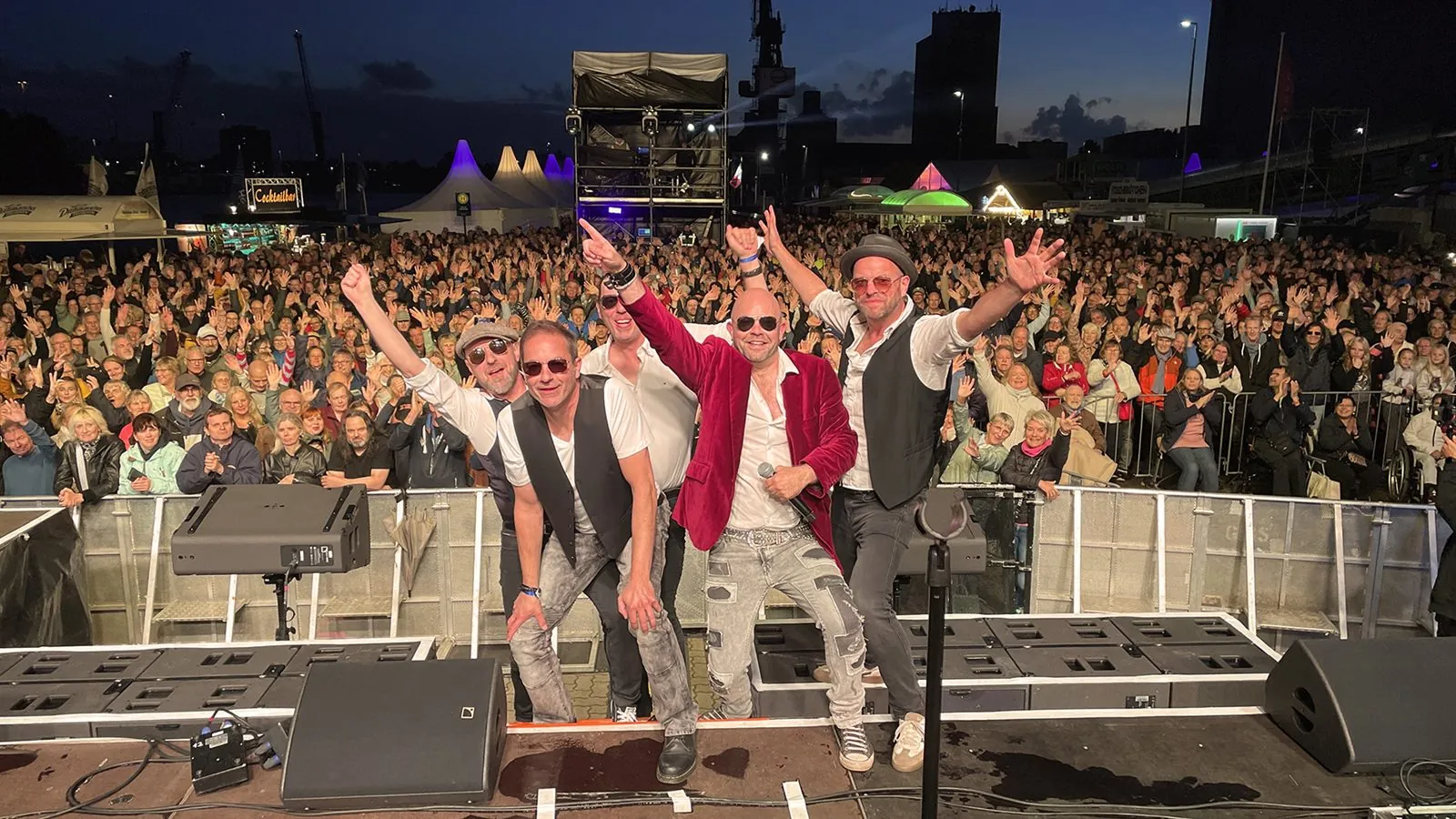 Die fünf Musiker von Johnny Stone heben die Arme vor einer jubelnden Publikumsmenge beim SH Netz Cup 2026.